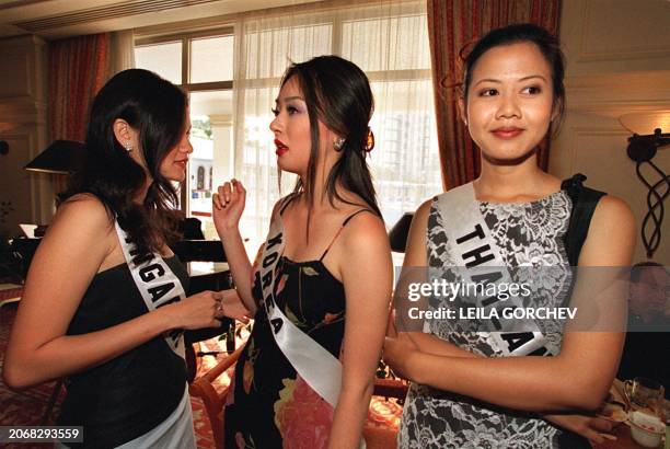Miss Singapore 2000, Eunice Elizabeth Olsen, Miss Korea 2000, Kim Youn-Joo and Miss Thailand 2000, Kulthida Yenprasert chat in the lounge of a...