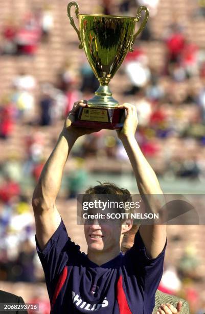 Soccer player Brian McBride raises his trophy for the Top Goal Scorer after the final match between the US and Costa Rica for the Gold Cup at the...