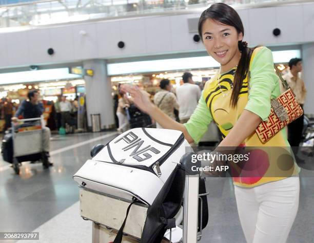 Li Tao, a 25-year-old office worker, poses prior to her departure at the Beijing Capital Airport, 13 September 2003, for the southern tropical resort...