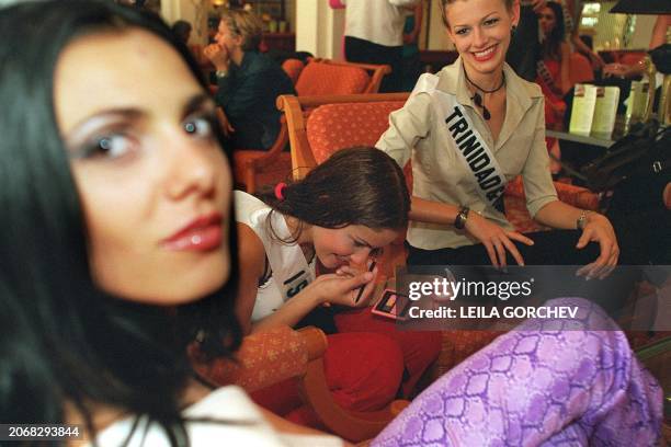 Miss Israel 2000, Nirit Bakchi applies makeup as Miss Bulgaria 2000, Magdalina Valtchanova and Miss Trinidad and Tobago look on, in the lounge of a...