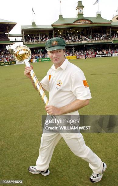 The Australian captain Steve Waugh displays the ICC World Championship Test Trophy after defeating South Africa on the fourth day of the third Test...