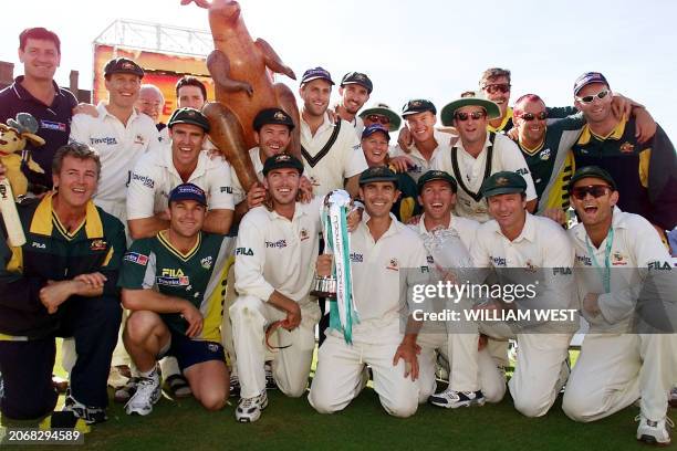 The victorious Australian cricket team poses with the trophies after defeating England on the final day of the fifth Test Match at the Oval in London...