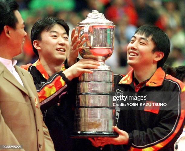 Members of the Chinese men's team, Liu Guoliang and Ma Lin , hold the trophy for the men's team event at the World Table Tennis Championships in...