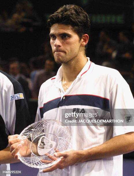Australian mark philippoussis holds the second place trophy after losing the against Australian mark philippoussis holds the second place trophy after losing the against