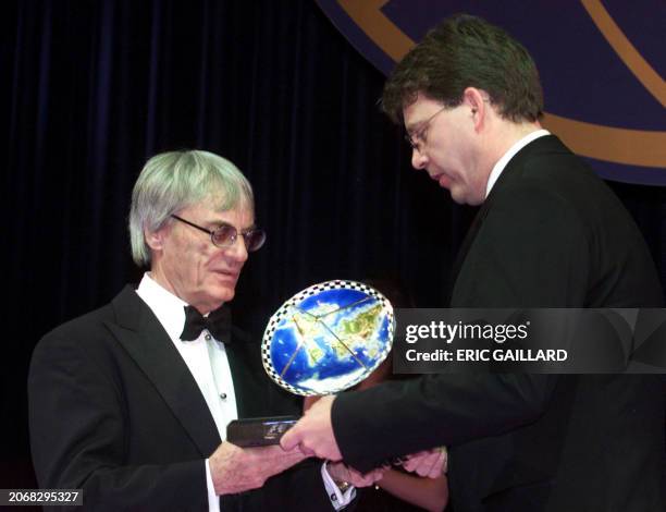 Bernie Ecclestone OF England gives a TV trophy to RTL head of sport Manfred Loppe during the FIA pricegiving gala in Monte Carlo 08 December 2000....