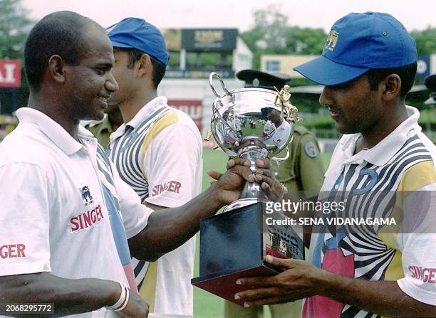 Sri Lanka skipper Sanath Jayasuriya hands the test cup to deputy Mahela Jayawardena 04 October, 1999 after rain washed out their third and final test...