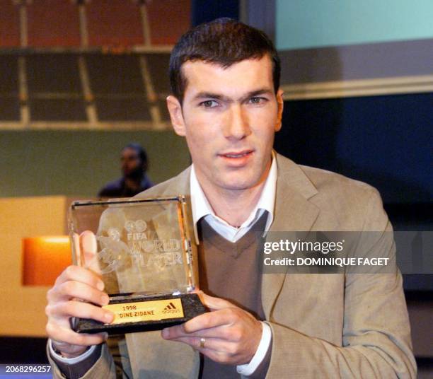 French soccer player Zinedine Zidane holds the FIFA's trophy of best player of the world for 1998, at a ceremony in Barcelona 01 February. Zidane...