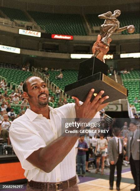 Karl Malone of the NBA's Utah Jazz holds up his 1998-99 NBA MVP trophy to a crowd of several thousand at the Delta Center in Salt Lake City, Utah, 10...