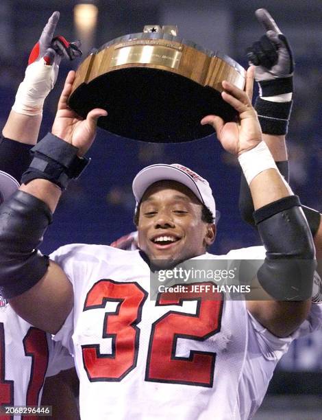 Running back Jamal Anderson of the Atlanta Falcons celebrates with the George S. Halas trophy after winning in overtime against the Minnesota Vikings...