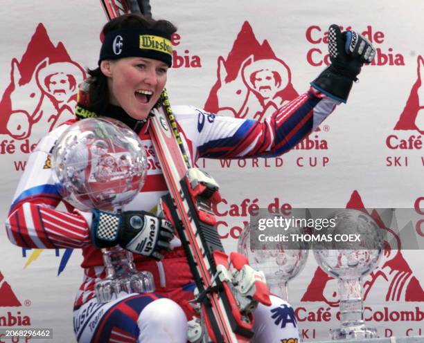 Austrian Alexandra Meissnitzer celebrates on the podium with her three cristal globes, the overall World Cup winner's globe, the Super-G and the...