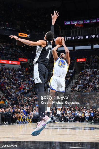 Chris Paul of the Golden State Warriors shoots the ball during the game as Victor Wembanyama of the San Antonio Spurs plays defense on March 11, 2024...