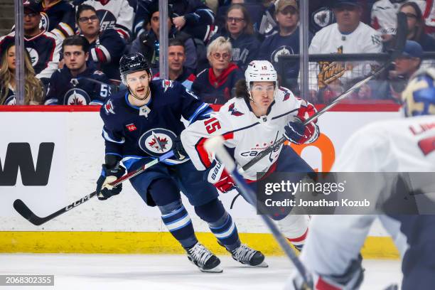 Colin Miller of the Winnipeg Jets and Sonny Milano of the Washington Capitals follow the play down the ice during second period action at the Canada...