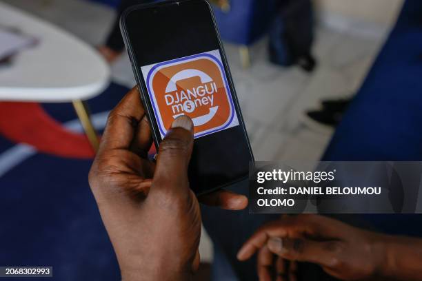 This photograph taken in Yaounde, on February 17, shows the Djangui Money logo on a mobile phone. In many African countries, the tontine is a popular...