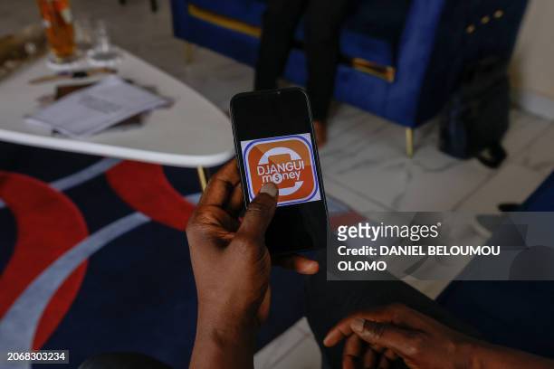 This photograph taken in Yaounde, on February 17, shows the Djangui Money logo on a mobile phone. In many African countries, the tontine is a popular...