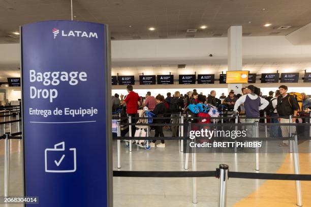 Passengers stand in a line at the LATAM Airlines check-in counters at Auckland International Airport in Auckland on March 12 a day after a...