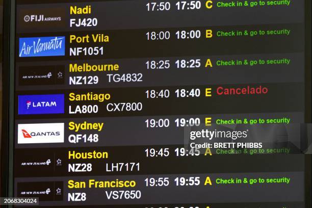 Screens display flight information for a LATAM Airlines flight at Auckland International Airport in Auckland on March 12 a day after a Boeing-made...