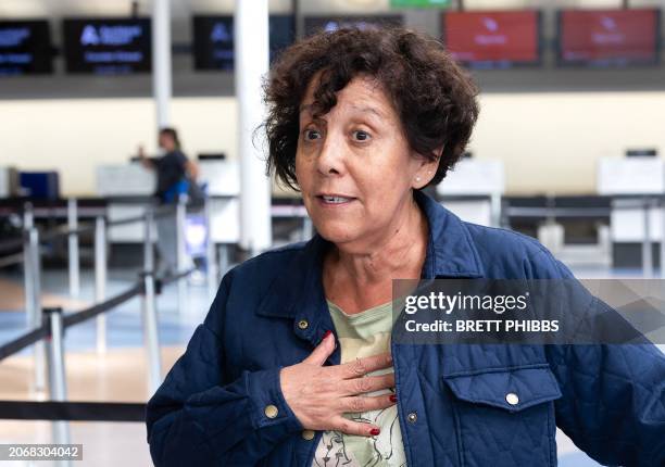 Passenger Verinica Martinez gestures as she stands in front of a line of people at the LATAM Airlines check-in counters at Auckland International...