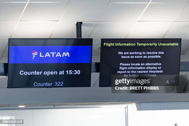 Screens above the LATAM Airlines check-in counters display flight information at Auckland International Airport in Auckland on March 12 a day after a...