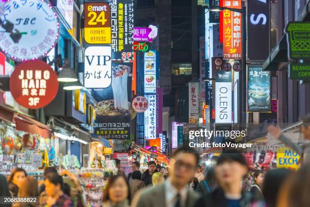 corea multitudes de compradores en la concurrida calle nocturna myeong-dong seúl - myeong dong fotografías e imágenes de stock