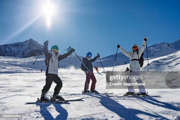 mutter und kinder im teenageralter fahren an einem sonnigen wintertag gemeinsam in einem gletscherskigebiet in den alpen - wintersportort stock-fotos und bilder