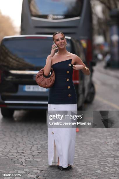 Clemence is seen wearing a blue and gold button shoulderless top, white long skirt, brown handbag and black heels and golden earrings outside Nina...