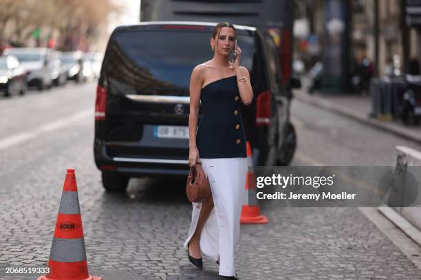 Clemence is seen wearing a blue and gold button shoulderless top, white long skirt, brown handbag and black heels and golden earrings outside Nina...