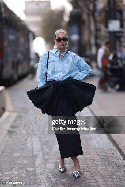 Alex Kaiser seen wearing a babyblue stripped blouse, a big black bow, black stripped long skirt and silver heels, silver necklace chains and black...