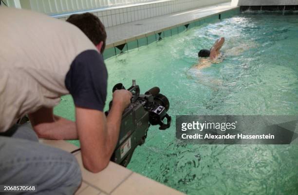 Camera operator at the pool's edge, filming German swimmer Sandra Volker during the production of the 'Faszination Freistilschwimmen' video, in...