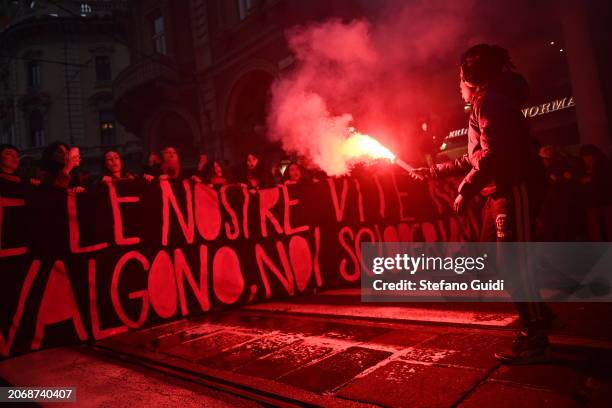 Young person holds a red smoke hand flare during a protest on International Women's Day on March 8, 2024 in Turin, Italy. Festa della Donna,...