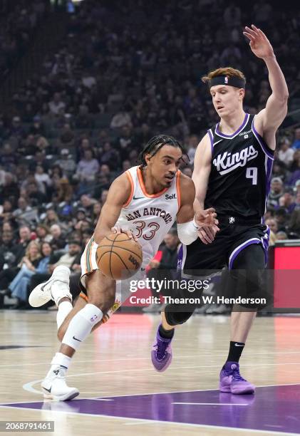 Tre Jones of the San Antonio Spurs drives to the basket on Kevin Huerter of the Sacramento Kings during the first quarter of an NBA basketball game...