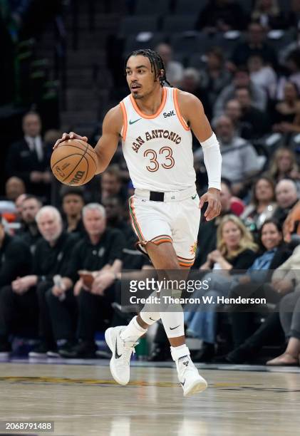 Tre Jones of the San Antonio Spurs dribbles the ball up court against the Sacramento Kings during the first quarter of an NBA basketball game at...
