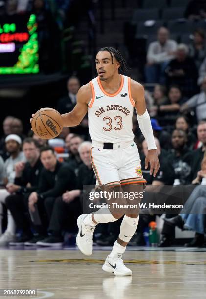 Tre Jones of the San Antonio Spurs dribbles the ball up court against the Sacramento Kings during the first quarter of an NBA basketball game at...