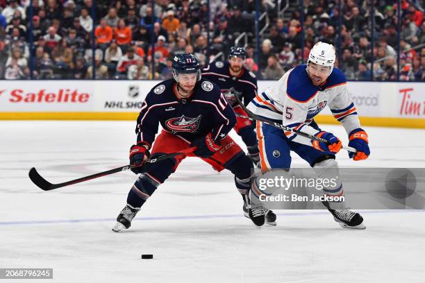 Justin Danforth of the Columbus Blue Jackets and Cody Ceci of the Edmonton Oilers skate after a loose puck during the third period of a game at...