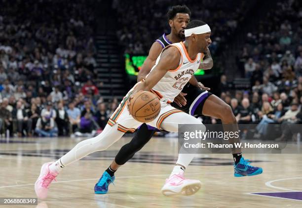 Malaki Branham of the San Antonio Spurs drives to the basket on Malik Monk of the Sacramento Kings during the first quarter of an NBA basketball game...