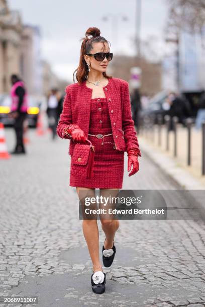 Anna Rosa Vitiello wears sunglasses, earrings, a necklace, a red full look, a tweed jacket, a low-neck top, a thin belt, a mini skirt , a red tweed...