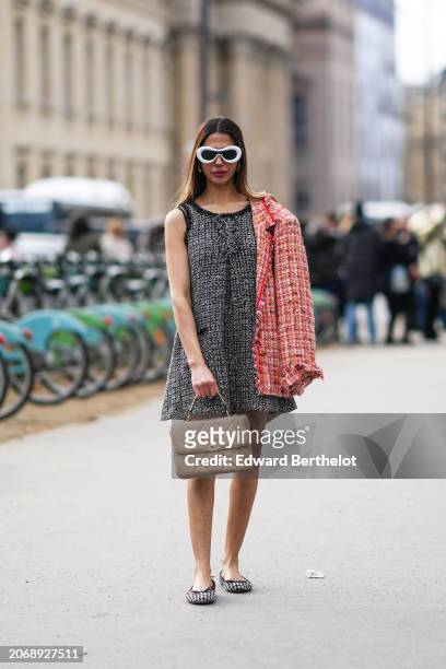 Khadija Farid wears white sunglasses , a black tweed sleeveless short dress , a red tweed jacket , a beige quilted leather bag, flat shoes, outside...