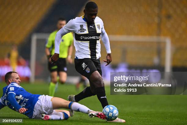 Ange-Yoan Bonny tackles during Serie B match between Parma and Brescia at Stadio Ennio Tardini on March 08, 2024 in Parma, Italy.