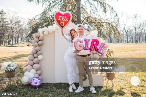 portrait d’une femme enceinte souriante et de son mari tenant des ballons lors d’une fête de révélation de genre - annonce naissance photos et images de collection