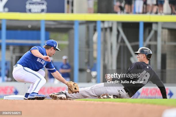 Davis Schneider of the Toronto Blue Jays tags Anthony Rizzo of the New York Yankees out at second base in the fourth inning during a 2024 Grapefruit...
