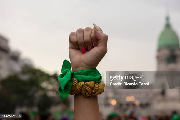 Detail of a woman's fist wearing a pro-choice green handkerchief during a demonstration called to commemorate the International Women's Day on March...