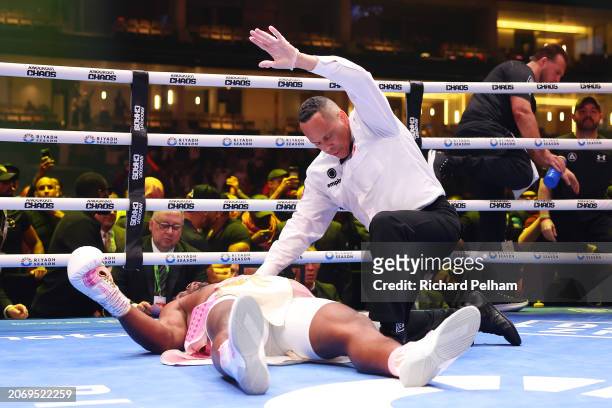 Francis Ngannou is knocked down for the third time as Referee Ricky Gonzalez checks on him during the Heavyweight fight between Anthony Joshua and...