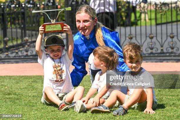 Jamie Kah poses with the late Dean Holland children after receiving the Dean Holland trophy after riding Cylinder to win Race 5, the Yulong Newmarket...