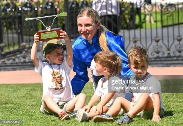 Jamie Kah poses with the late Dean Holland children after receiving the Dean Holland trophy after riding Cylinder to win Race 5, the Yulong Newmarket...