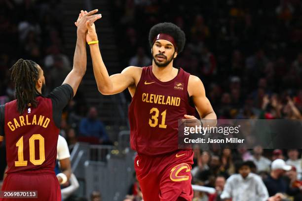 Darius Garland celebrates with Jarrett Allen of the Cleveland Cavaliers after Allen scored during overtime against the Minnesota Timberwolves at...