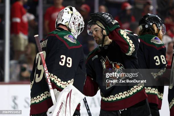 Connor Ingram of the Arizona Coyotes and Michael Carcone celebrate after a 4-0 win over the Detroit Red Wings at Mullett Arena on March 08, 2024 in...