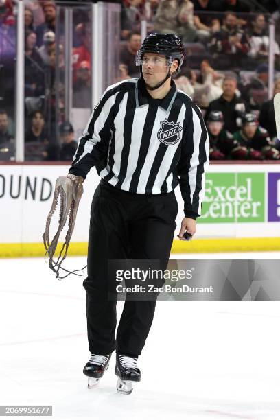 Linesman Kiel Murchison skates with an octopus that was thrown onto the ice during the third period of a Arizona Coyotes and Detroit Red Wings game...