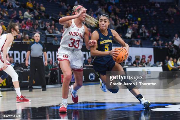 Laila Phelia of the Michigan Wolverines drives to the basket against Sydney Parrish of the Indiana Hoosiers during the second half of a Big Ten...