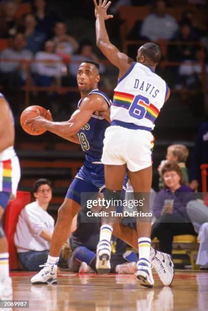 Tony Campbell of the Minnesota Timberwolves looks to pass while defended by Walter Davis of the Denver Nuggets in a game at McNichols Sports Arena in...