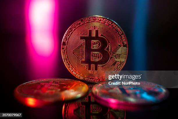 Bitcoins golden physical coin illustration on dark black background with reflection and vibrant color light illumination. Visual representations of...