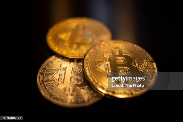 Bitcoins golden physical coin illustration on dark black background with reflection and vibrant color light illumination. Visual representations of...